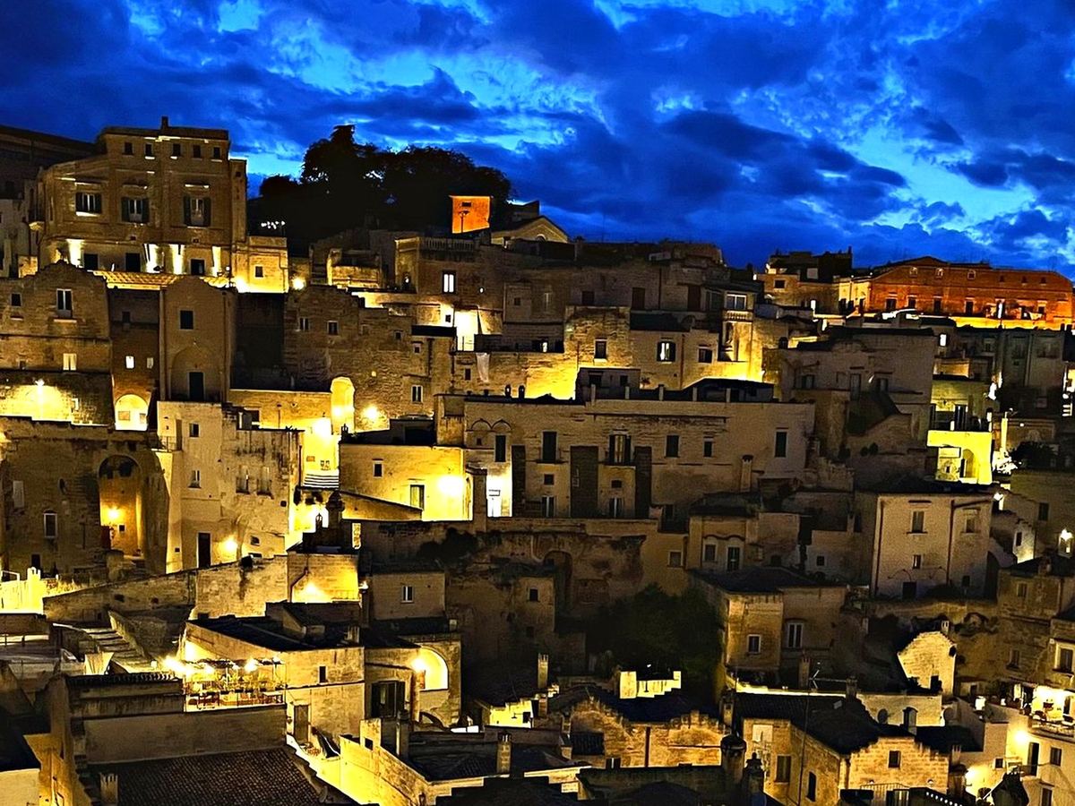 Les Sassi de Matera illuminés la nuit sous un ciel bleu profond